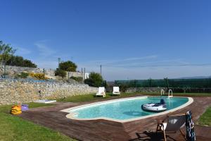 a swimming pool with a boat in a yard at Casal Serrano Charme e Tranquilidade in Reguengo Grande