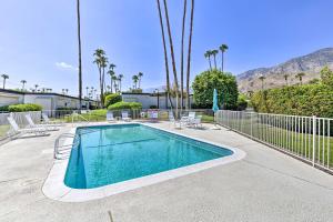 a swimming pool with chairs and a fence at Community Perks BBQ-Ready Palm Springs Condo! in Palm Springs