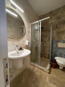 a bathroom with a sink and a shower and a toilet at MaSaLa Otel in Alaçatı