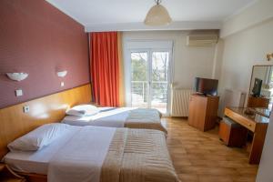 a hotel room with two beds and a television at Giannis Hotel in Kimméria