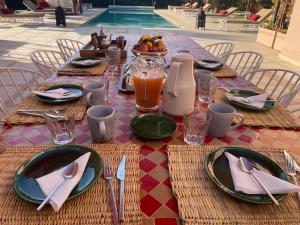 - une table avec des assiettes et des ustensiles en haut dans l'établissement Villa Aljana Marrakech, à Marrakech