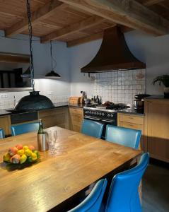 una cocina con una mesa de madera y un bol de fruta. en Casa Fuori en Oirschot