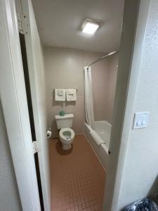 a small bathroom with a toilet and a bath tub at Royal Inn Motel in Fredericksburg