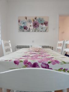 a white table with purple flowers on it at Kuća za odmor BIĐ 