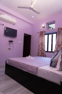 a bedroom with a bed with purple walls at the new view in Jodhpur