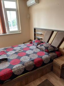 een slaapkamer met een bed met een kleurrijk dekbed bij Лудогорско бижу in Razgrad
