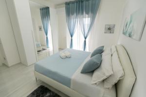 a bedroom with a bed with blue pillows and a window at [Crotone 5 Stelle] Free Parking, Netflix, Wi-Fi in Crotone