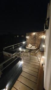 una terraza con 2 sillas y una mesa por la noche en Luminous appartment - Juliana Park free parking, en Utrecht