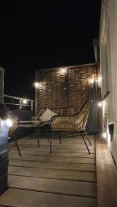 a wooden deck with a bench and lights at night at Luminous appartment - Juliana Park free parking in Utrecht