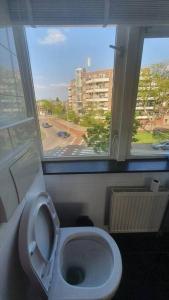 a bathroom with a toilet with a large window at Luminous appartment - Juliana Park free parking in Utrecht