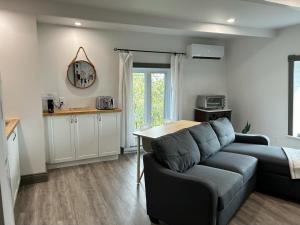 a living room with a couch and a table at Petite Plaisance Appartements in La Malbaie