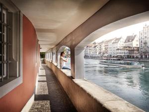 Eine Frau, die auf einer Brücke neben einem Fluss sitzt. in der Unterkunft Pedestrian Area close to Bahnhofstrasse in Zürich