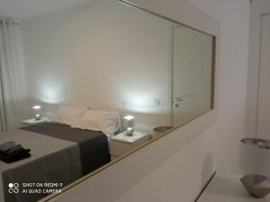 a mirror reflecting a bed in a white room at Valevi 111 in Castellana Grotte