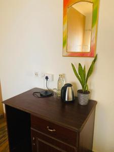 a wooden dresser with a mirror and a plant on it at hello beach view resorts in Varkala