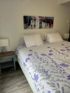 a bedroom with a bed and a painting on the wall at Petite Plaisance Appartements in La Malbaie