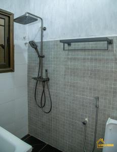 y baño con ducha con cabezal de ducha. en La Villa Norah, en Ouagadougou