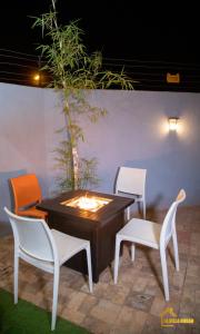 2 sillas y una mesa con una vela en el patio en La Villa Norah, en Ouagadougou