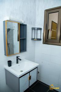 y baño con lavabo y espejo. en La Villa Norah, en Ouagadougou