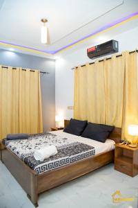 1 dormitorio con 1 cama grande y cortinas amarillas en La Villa Norah, en Ouagadougou