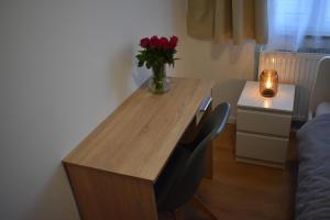 una scrivania in legno con un vaso di fiori sopra di Pension Bären a Großengstingen