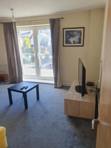 a living room with a tv and a coffee table at One bedroom Apartment in the heart of Horsham city centre in Horsham