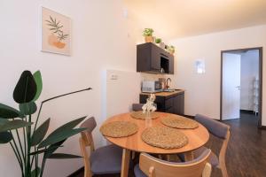 comedor con mesa y sillas y cocina en Global Living - Design Apartment I City Center I Beamer I Kitchen I Augsburg, en Augsburg