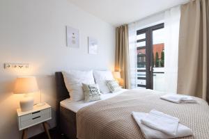 um quarto com uma cama com um candeeiro e uma janela em Global Living - Design Apartment I City Center I Beamer I Kitchen I Augsburg em Augsburg