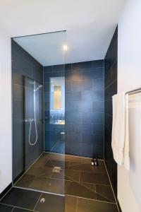 bagno con doccia e porta in vetro di Global Living - Design Apartment I City Center I Beamer I Kitchen I Augsburg a Augusta (Augsburg)