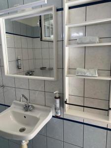 ein Bad mit einem Waschbecken und einem Spiegel in der Unterkunft Nisaki Mathraki B&B in Korfu-Stadt
