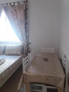 um quarto com uma mesa, uma cama e uma janela em ALBERTI em Shëngjin