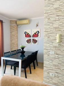 uma sala de jantar com uma mesa preta e cadeiras em Cosy Apartment Tirana em Tirana