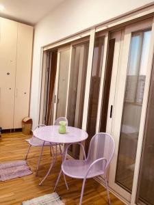 uma mesa e cadeiras num quarto com uma grande janela em Cosy Apartment Tirana em Tirana