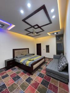 - une chambre avec un lit et un canapé dans l'établissement vista guest house, à Quetta