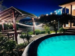a swimming pool in front of a house at night at Útulný malý domček s vírivkou in Košice