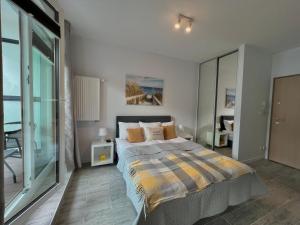 a bedroom with a bed and a large window at Studio Apartment Honey by Galeria Północna in Warsaw