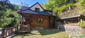 una cabaña de madera con una valla delante en Pod Zlatým vrchom, en Banská Štiavnica