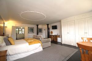 um quarto com uma cama, uma cadeira e uma mesa em Highfields Holidays bed & breakfast em Peterborough