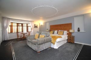 a bedroom with a bed and a couch and a chair at Highfields Holidays bed & breakfast in Peterborough