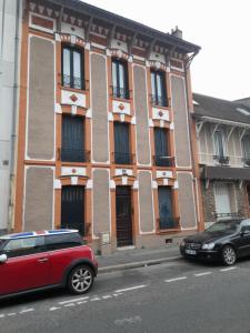 un coche rojo estacionado frente a un edificio en Studio Meublé, en Gentilly