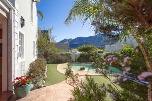 a backyard with a swimming pool and flowers at Sunflower Villa in Franschhoek in Franschhoek