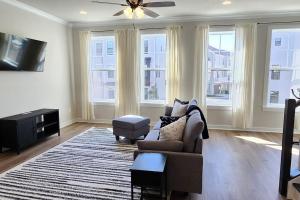 a living room with a couch and a tv and windows at Luxury in Fredericksburg in Fredericksburg