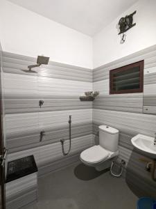 a bathroom with a toilet and a sink at Budget Home in Cochin