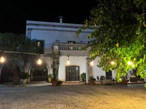 Biały dom ze światłami w nocy w obiekcie Masseria La Camardia w mieście Sava