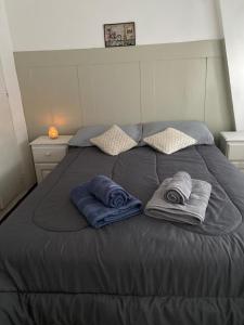 uma cama com duas toalhas e duas almofadas em Depto La Boca em Buenos Aires