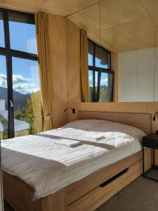 a bedroom with a large bed with a large window at CloudBase in Tukhlya
