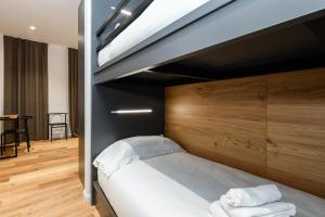 una camera da letto con letto a soppalco e lenzuola bianche di Hotel Mauro a Sirmione