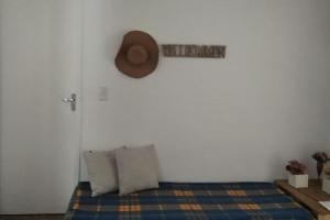 a room with a bed with a hat on the wall at Casa 346 in Ponta Grossa