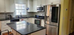 a kitchen with white cabinets and a stainless steel refrigerator at tom house in Tampa