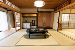 um quarto grande com uma mesa no meio em 大正の宿　浪漫邸 em Kani