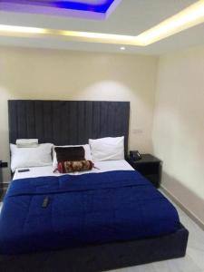 um quarto com uma cama grande e um cobertor azul em THE HAVEN SUITE em Lagos
